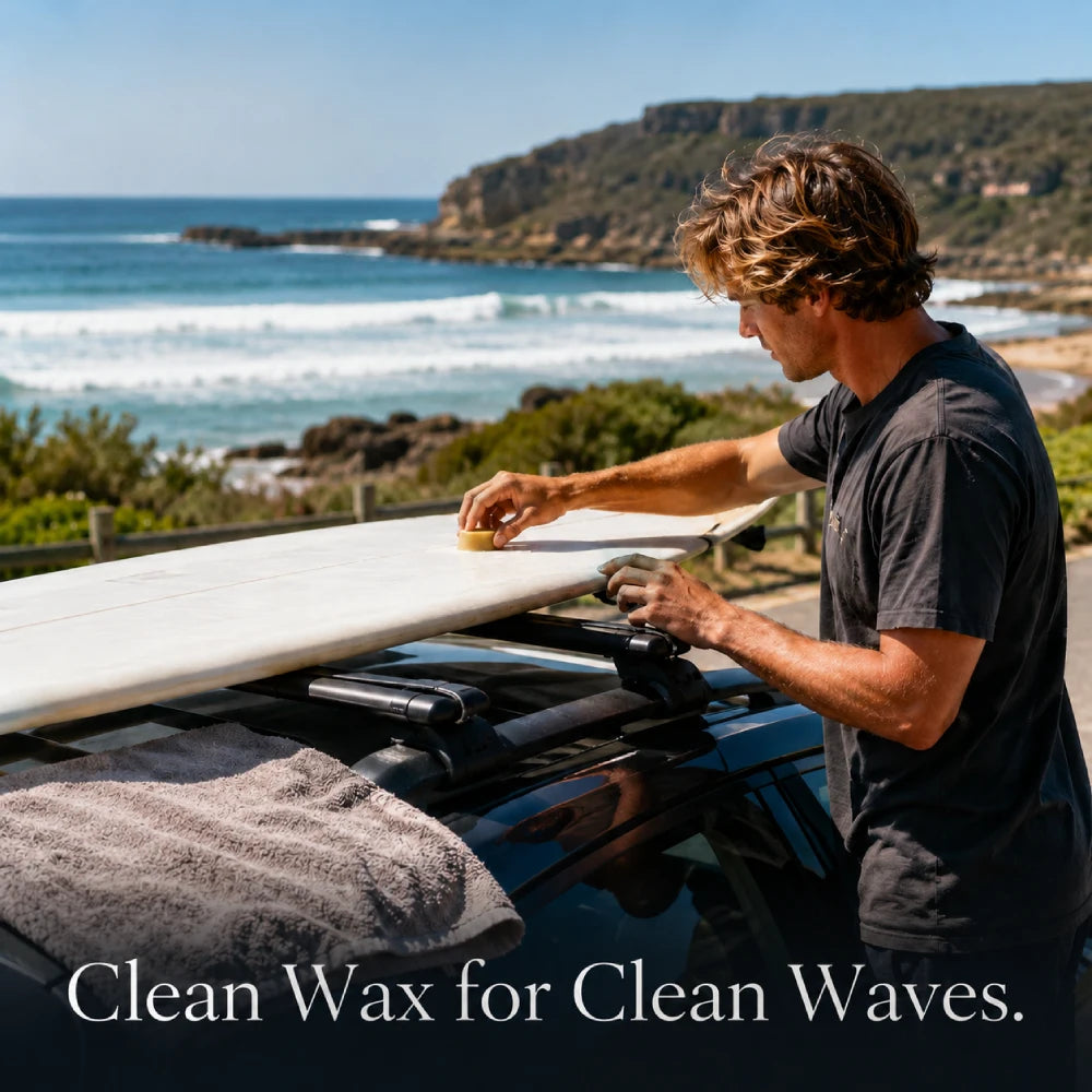 Surfer applying organic surf wax to a surfboard before a beach session